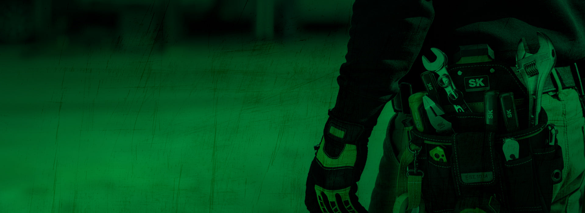 A close-up of a person's waist with a tool belt featuring various tools, set against a green background.